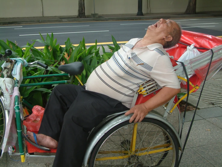 a person in a wheel chair laying on the side of the road