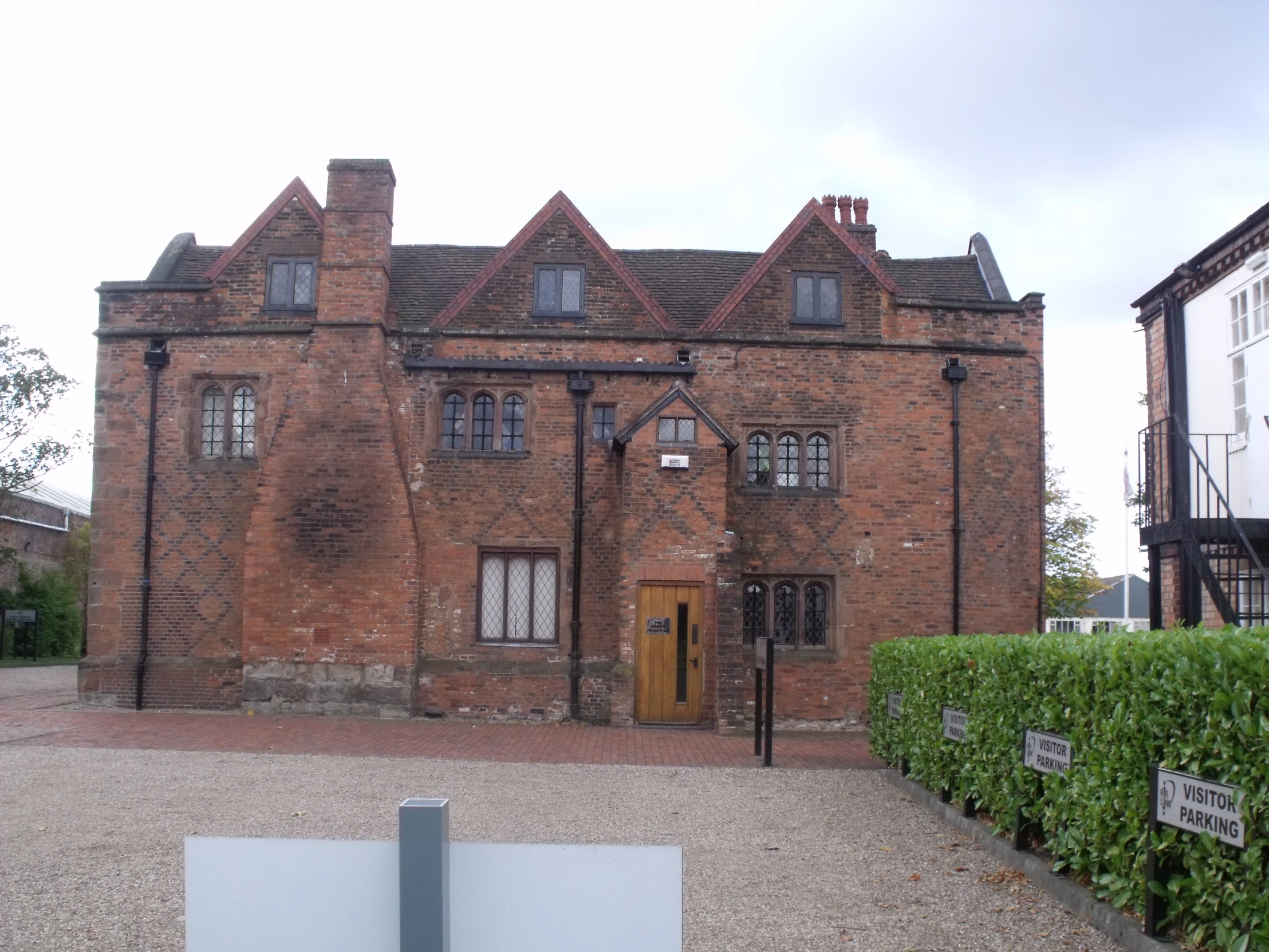 a brick building with several doors, many windows, and lots of ivy