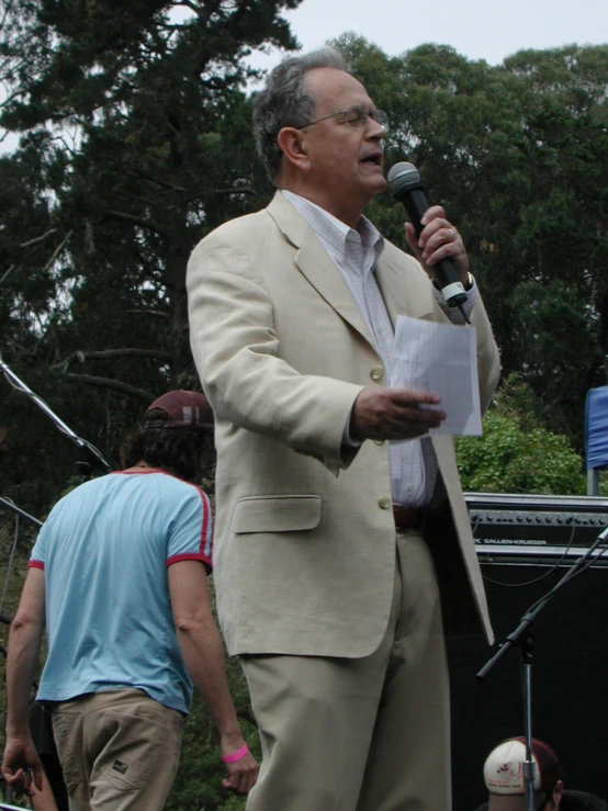 a man speaking into a microphone while standing next to another person