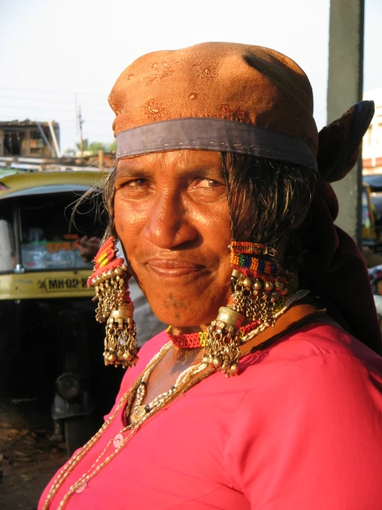 woman in pink shirt and large earrings wearing ear rings