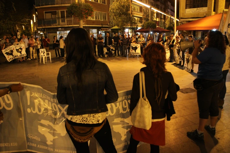 a couple of women standing next to each other holding a sign