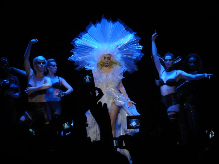 woman dressed as an alien with blue hair in the middle of a performance