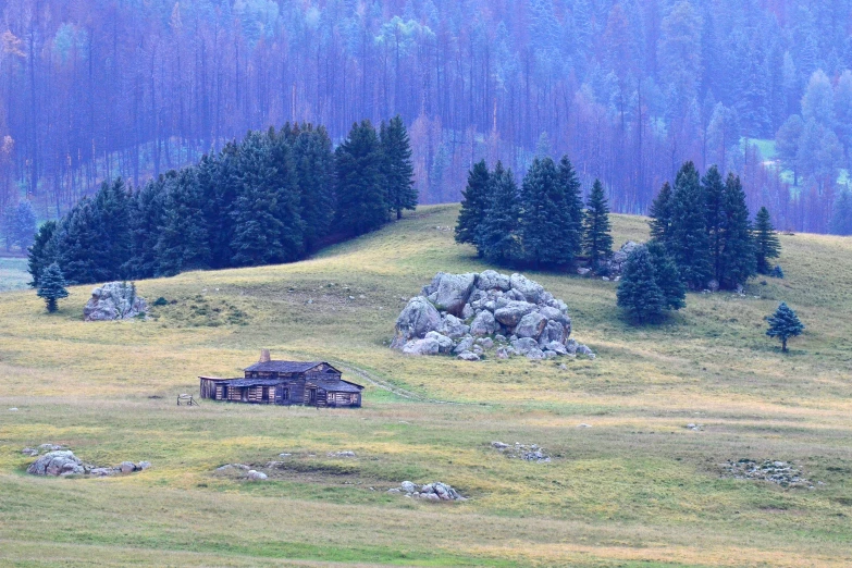 a run down building is sitting on top of a green hill