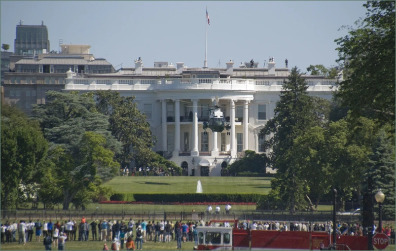 large crowd standing in front of the white house with many people