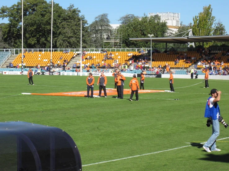 some people on a field with many orange stands