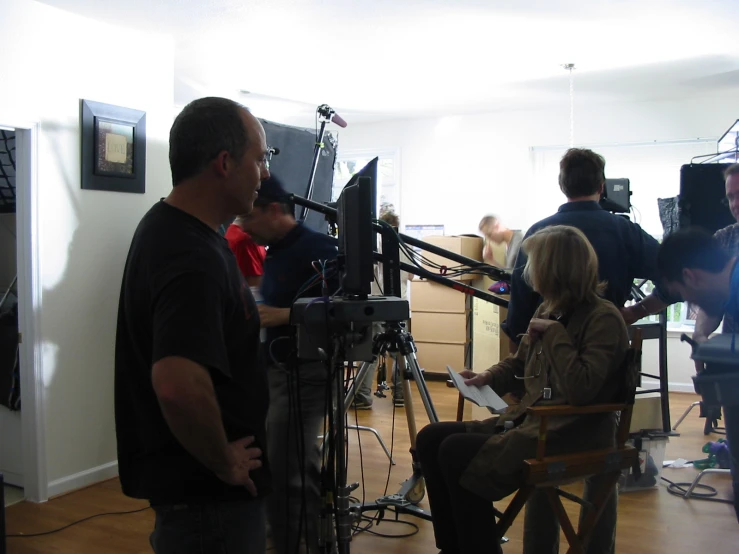 a group of people standing and sitting in front of recording equipment