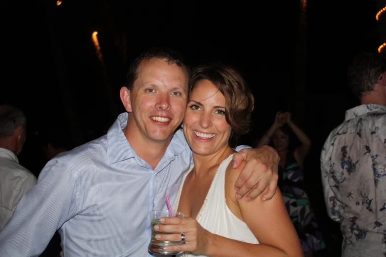 a man and woman are hugging on the dance floor