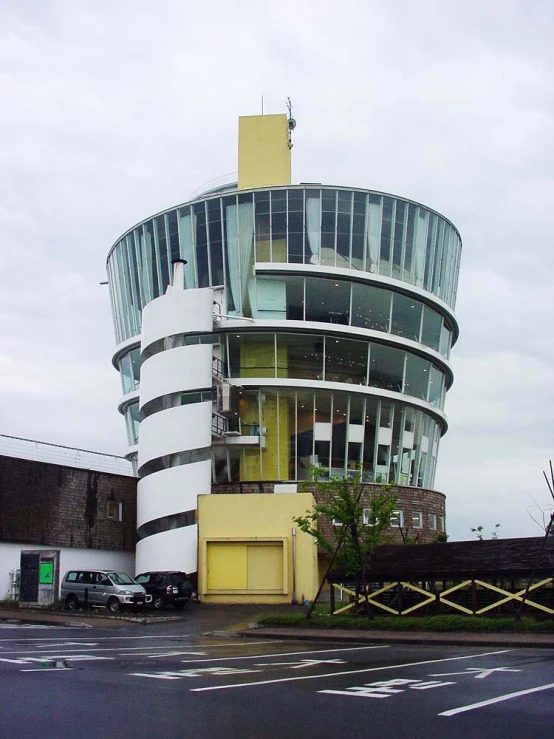 a large yellow circular building on a quiet city street