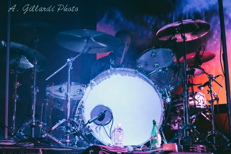 a stage setting with various drums, drum sticks and some other accessories