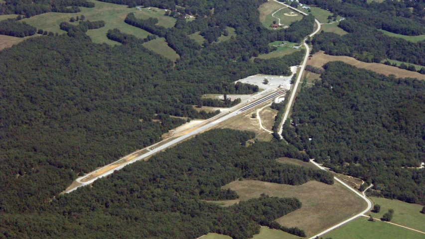 the aerial view of a highway and forest in the area