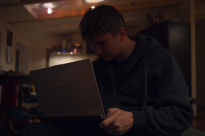 a man holding a small laptop computer on a chair