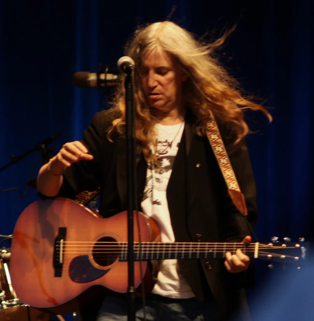 a woman with long hair playing a guitar