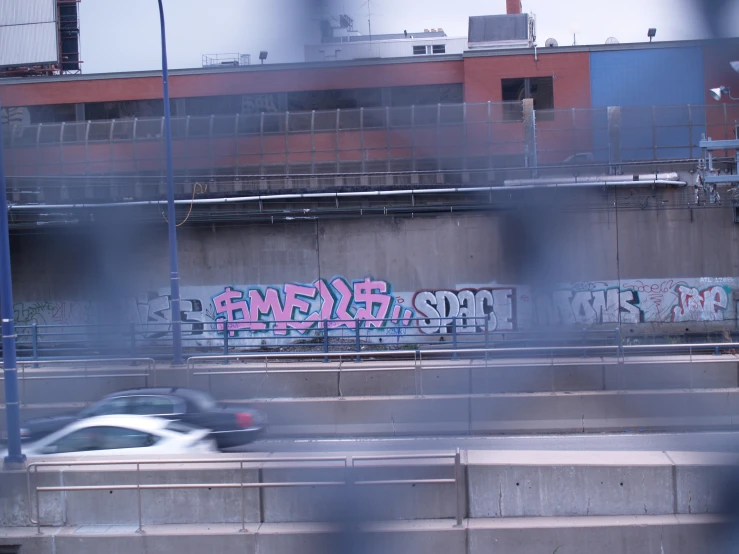 a white car driving past a graffiti covered wall