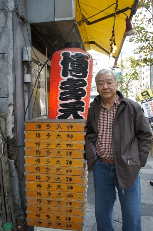 a man standing in front of a chinese writing display