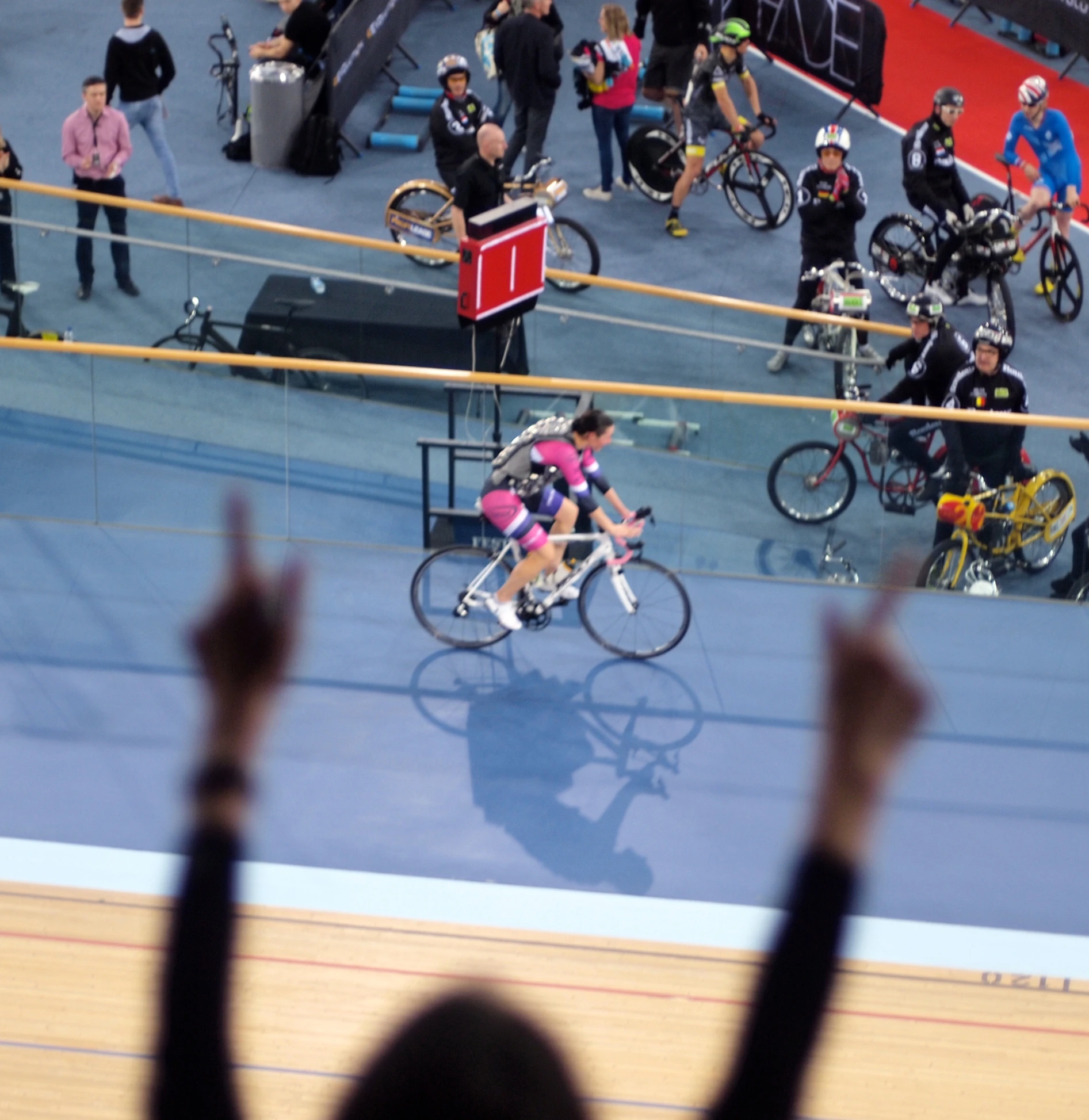 a bicycle race competitor waving at the crowd