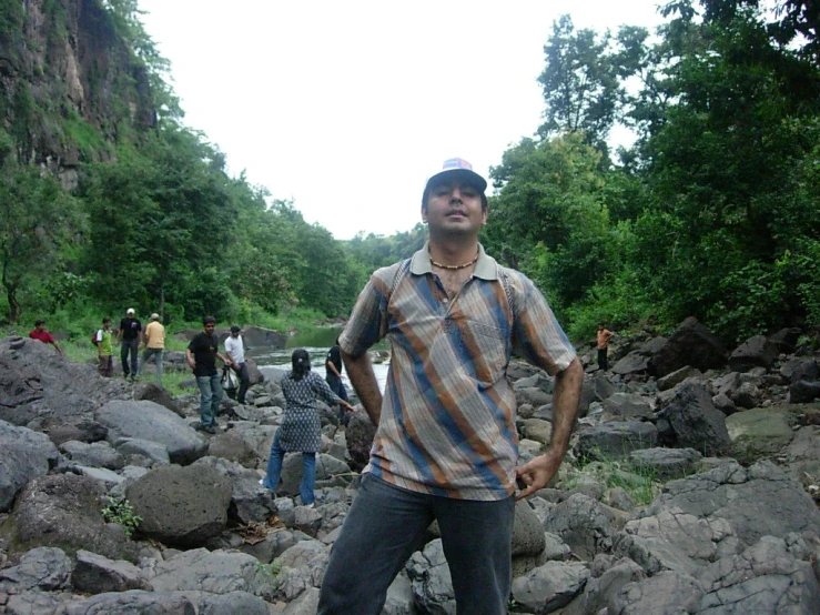 a man standing on a rocky river bank