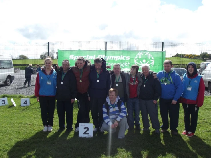 people with medal and medal at an outdoor competition