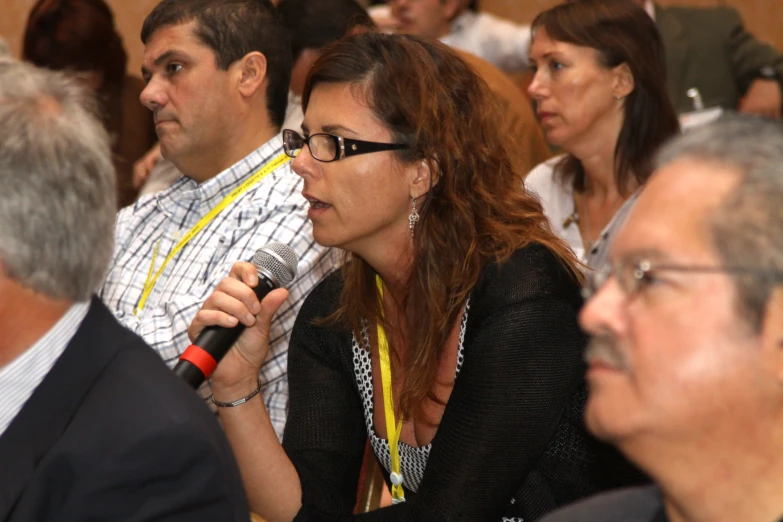 people sitting in a crowd are listening to speakers