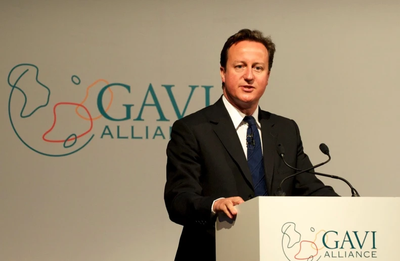 a man is standing at a podium in front of the company logo