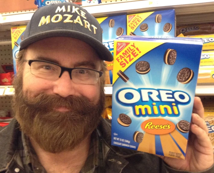 a man in a hat holds a box of oreo ice cream