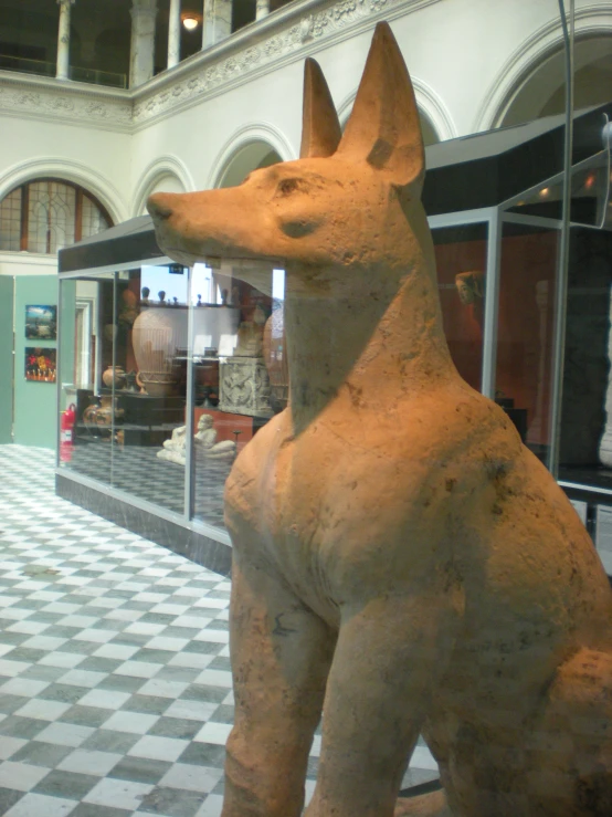 there is a statue of a dog that is in a museum