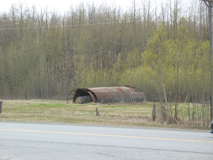 a road sign near an old structure near trees