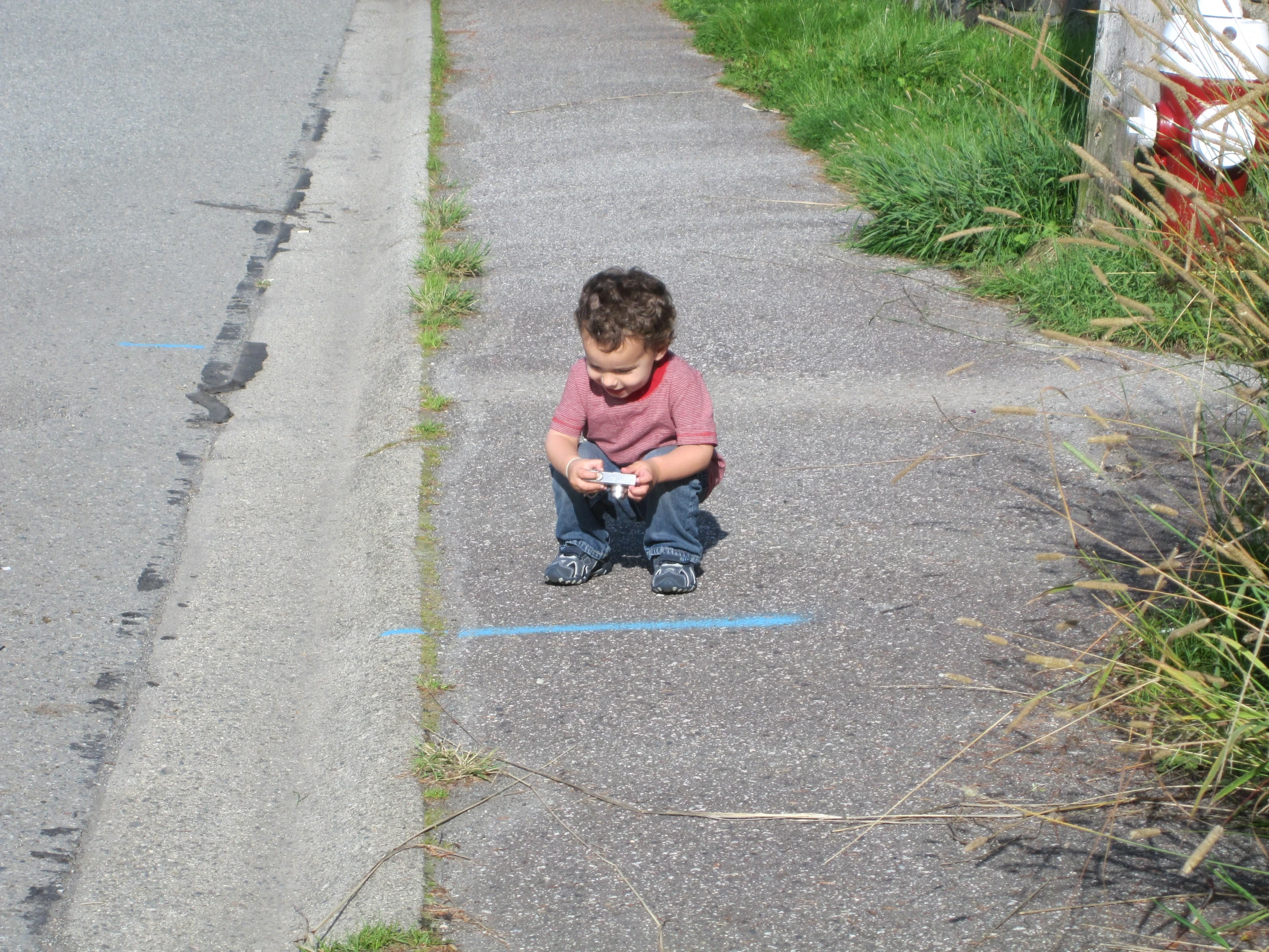 a little boy in a striped shirt playing with his toy