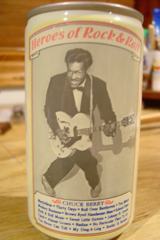 a close up of an advertit on a can with a man playing a guitar