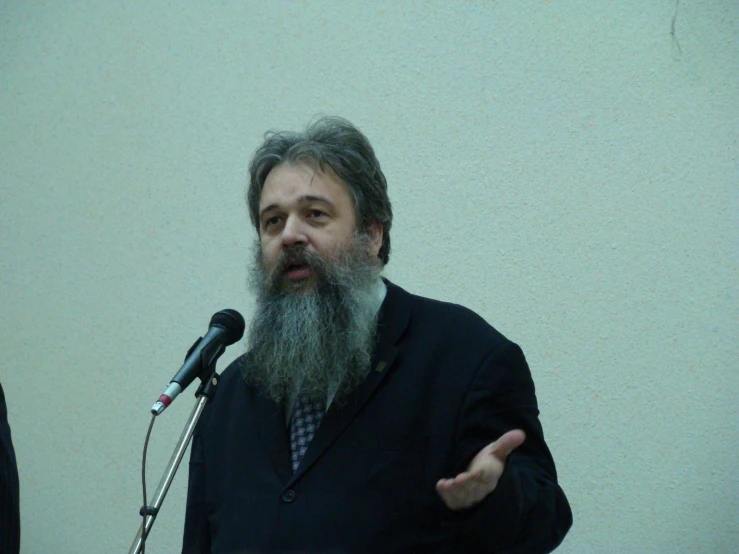 a man standing in front of a microphone giving a speech