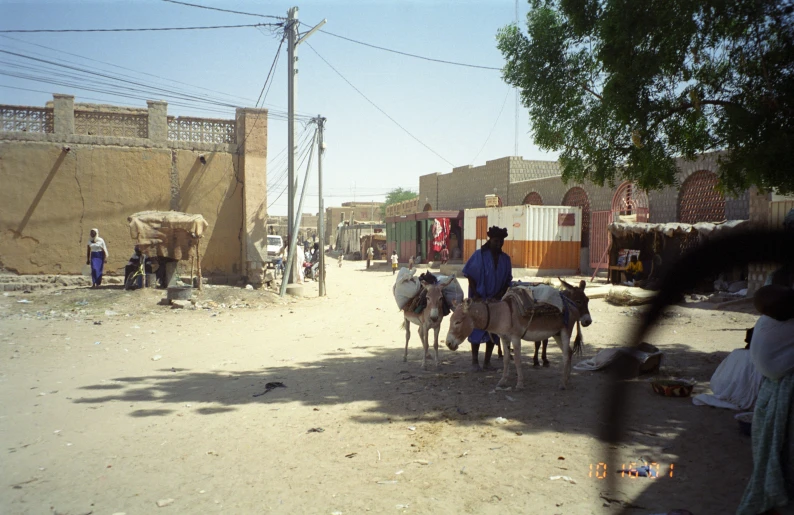 two people and one donkey on a dusty street