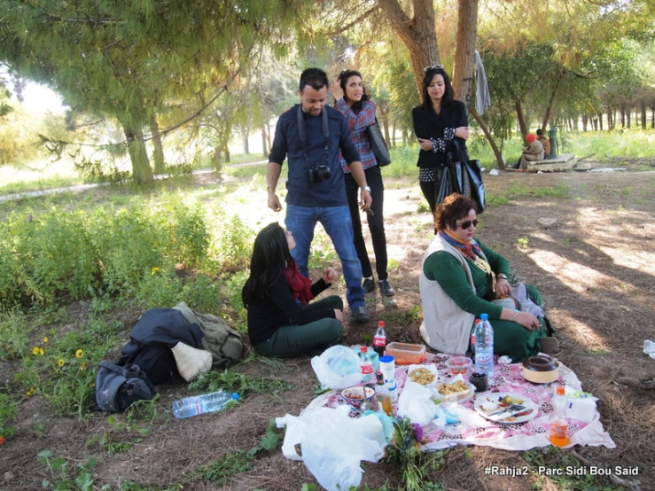 a group of people gather near some trees