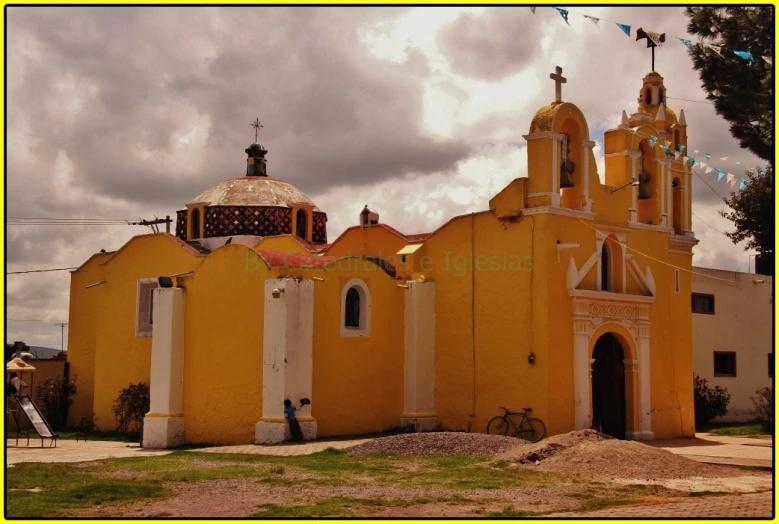 an old style yellow church with lots of windows