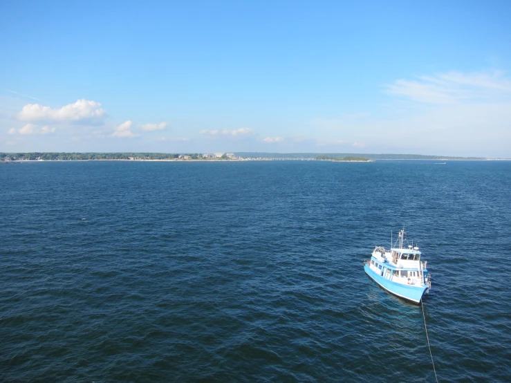 a large boat traveling through the ocean with small islands in the distance