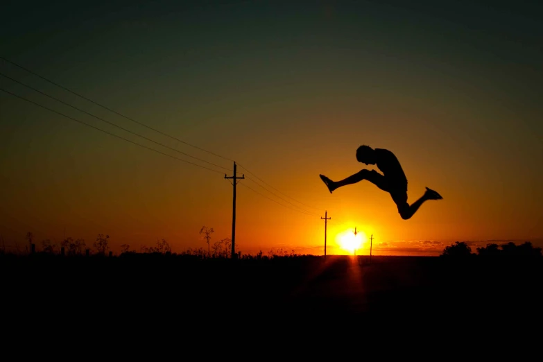 a silhouette of a person jumping in the air