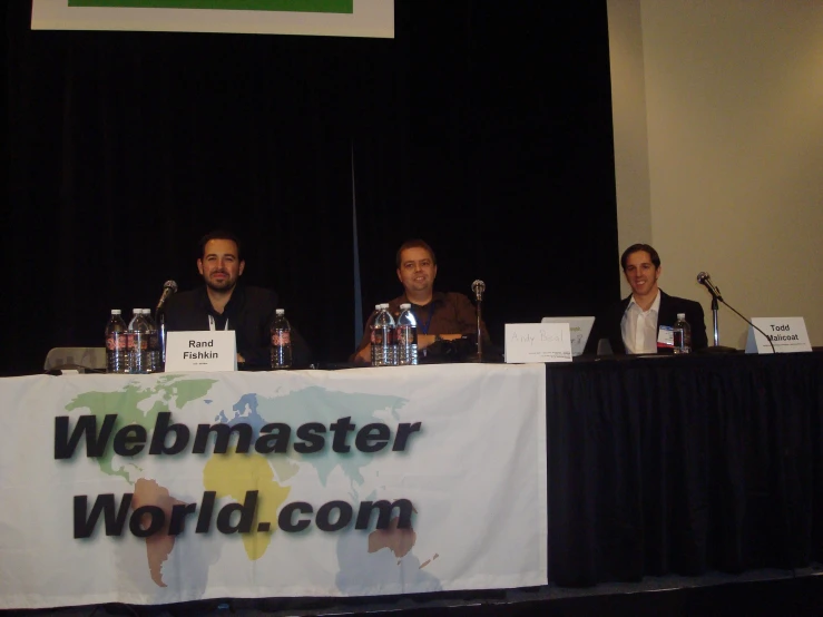 a group of men sitting at table with microphones