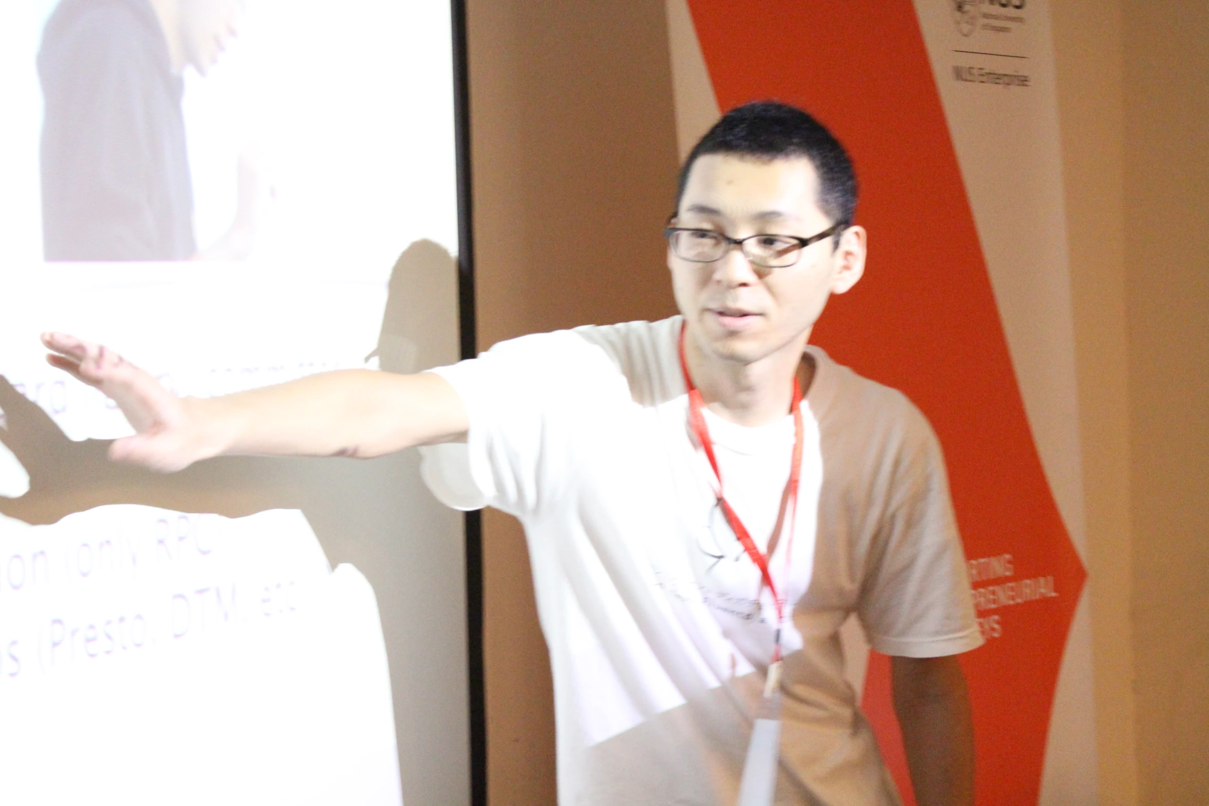 a man in a white shirt holding his hands out to a projector screen