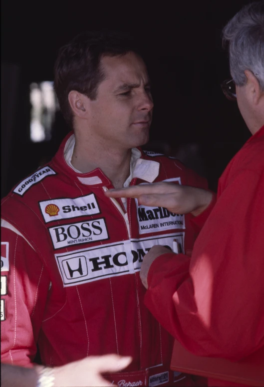 two men wearing red racing clothing are next to each other