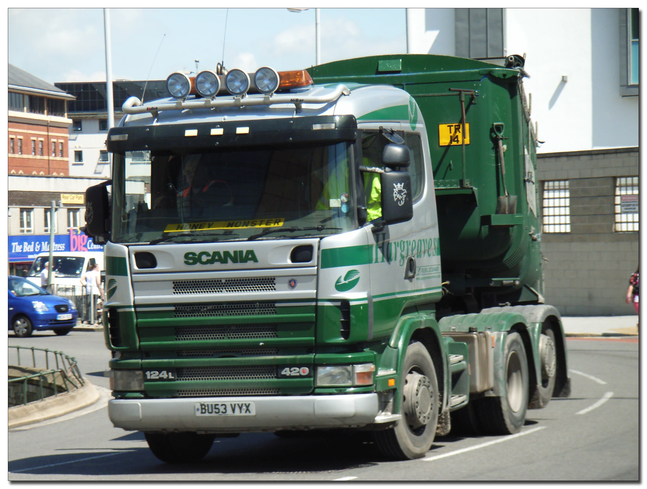 a big green truck driving down the street