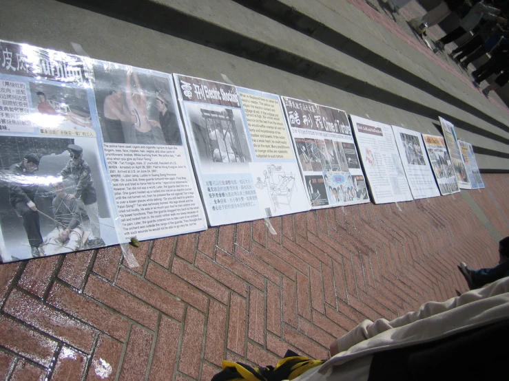 newspaper lined up on the ground with people standing around