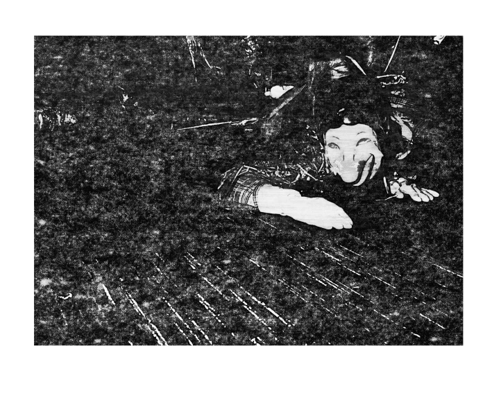 a man laying on the ground with his arm up and one foot behind his back