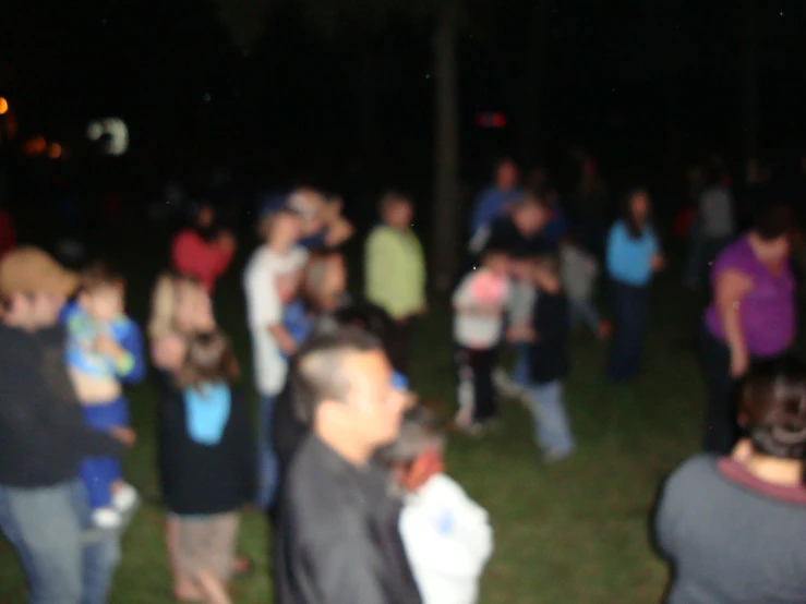 a large crowd of people are gathered outside at night