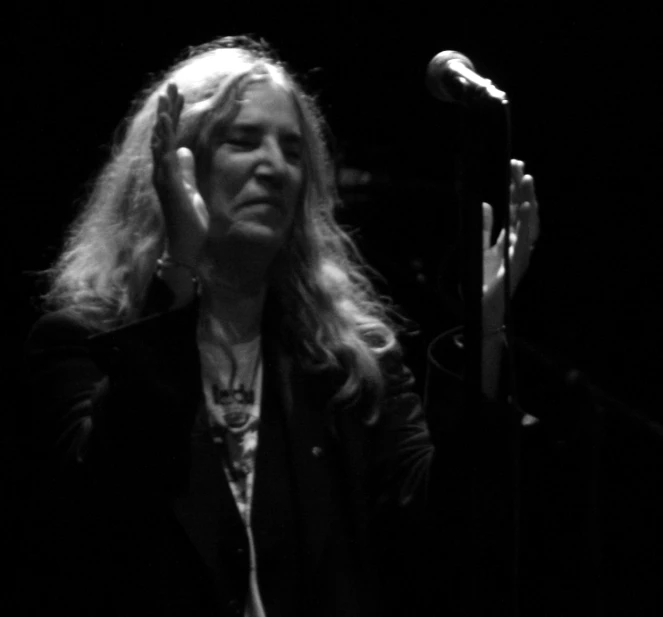 a woman with long hair sitting in front of a microphone