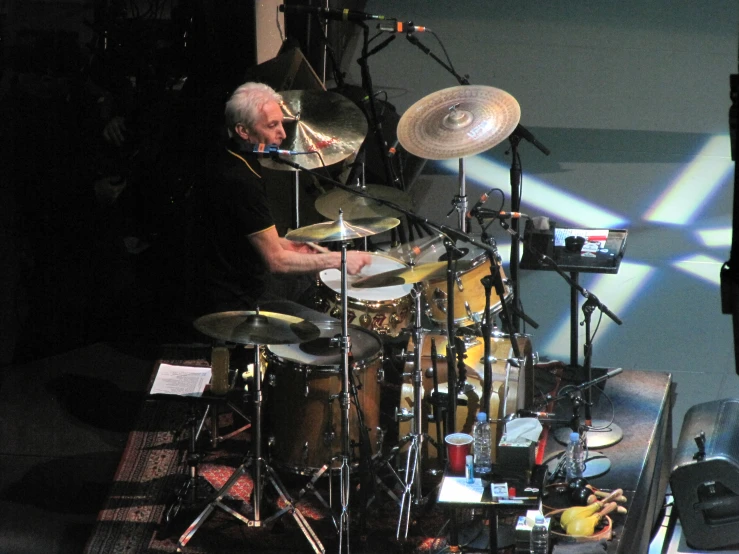 a man is holding his hand to his ears while playing drums