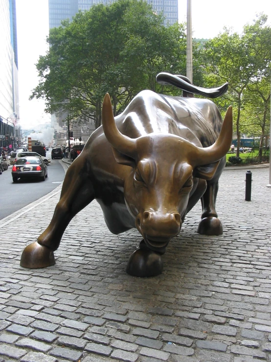 there is a sculpture of a bull that is walking on the street