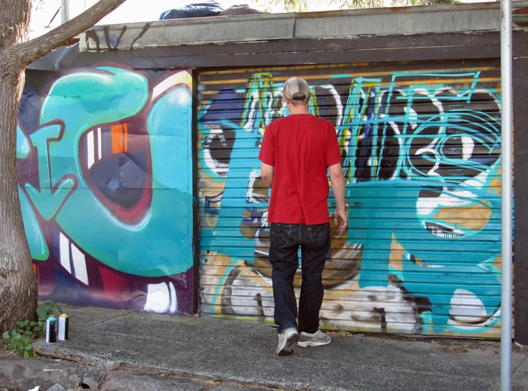 a man standing in front of a graffiti covered garage