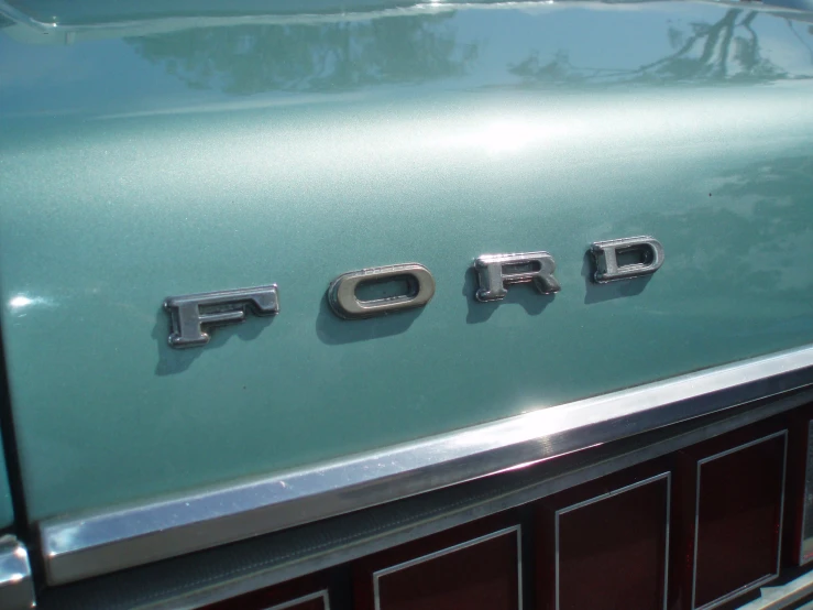 an old, very shiny ford emblem on the front of a car