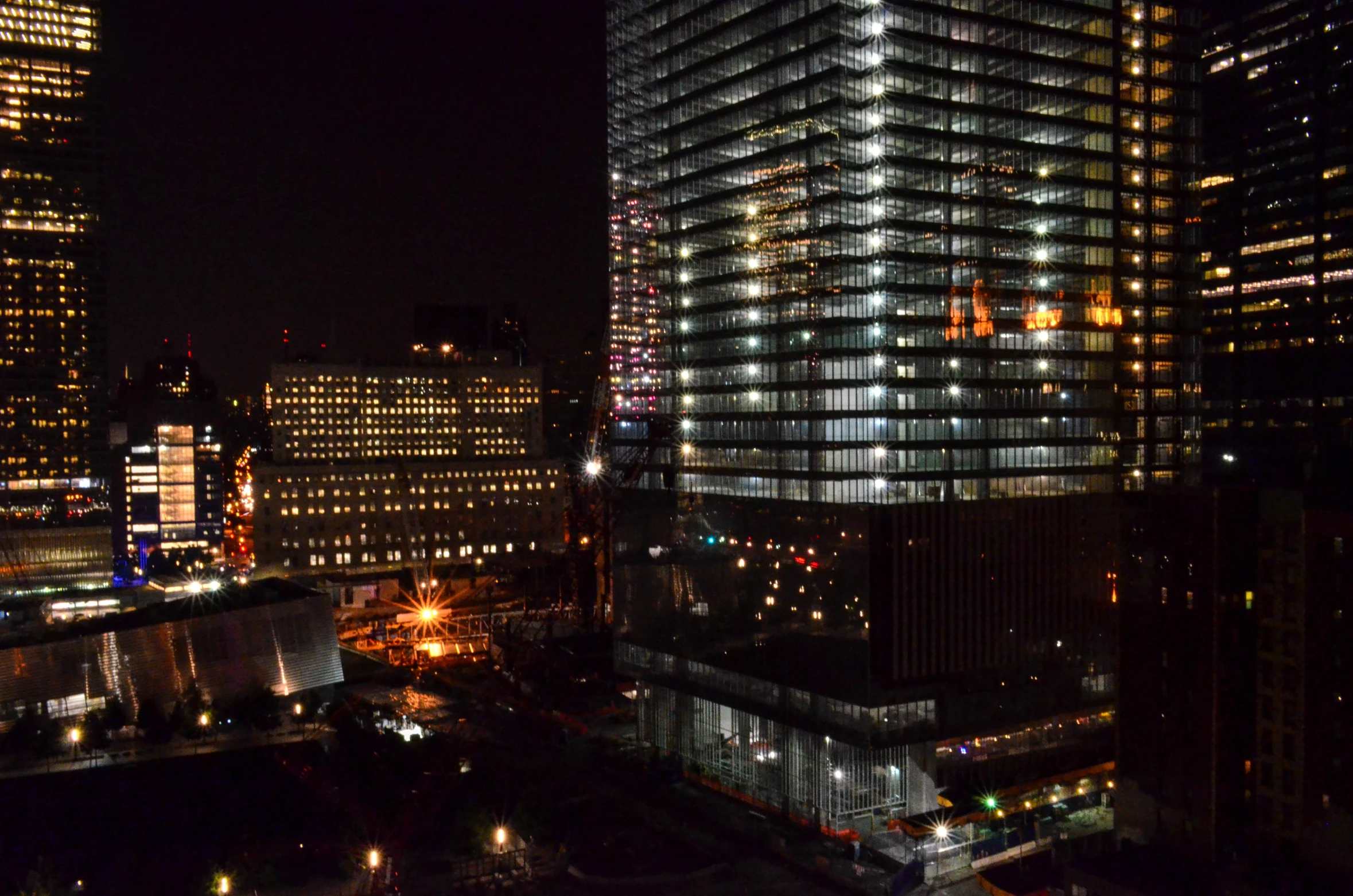 a skyscr at night with city lights in the background