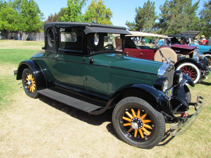 an antique model t car is parked near other cars