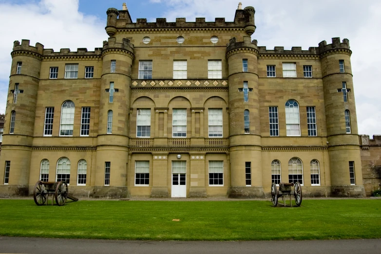 a large tan stone castle with bicycles parked on the lawn