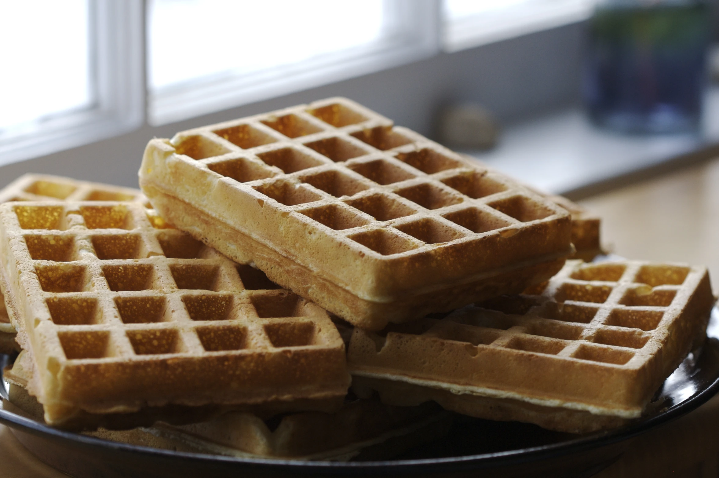 some waffles are stacked on a black plate